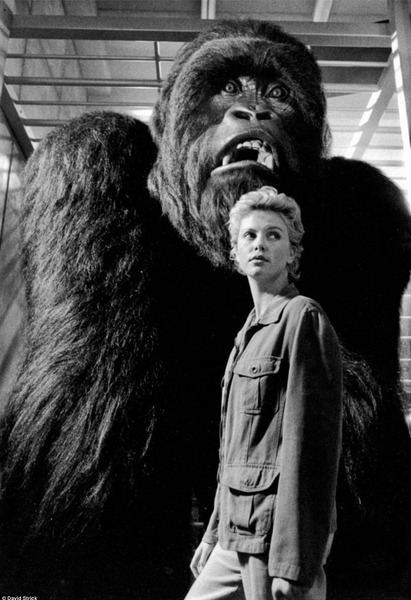 Американская актриса Шарлиз Терон стоит рядом с гигантской гориллой во время работы над фильмом Могучий Джо Янг в 1998 году.