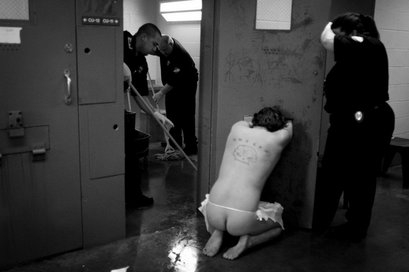 Сотрудники чистят и обыскивают камеру после того, как заключенный пытался навредить себе.
