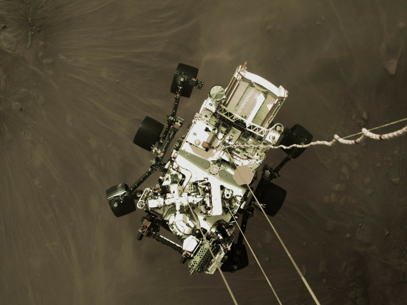 аппарат Perseverance подвешенный на тросах под посадочным модулем в момент спуска на поверхность Марса