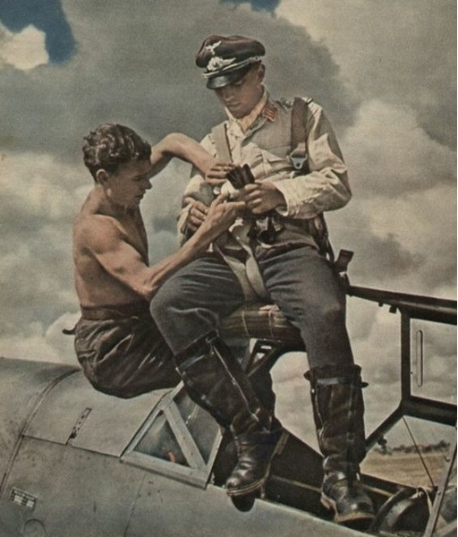 Техник люфтваффе оказывает помощь пилоту истребителя Мессершмит Bf.109