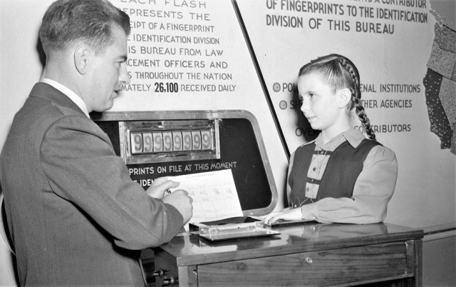 Специальный агент ФБР торжественно снимает стомиллионные отпечатки пальцев у кинозвезды Маргарет О’Брайен, 1946 год