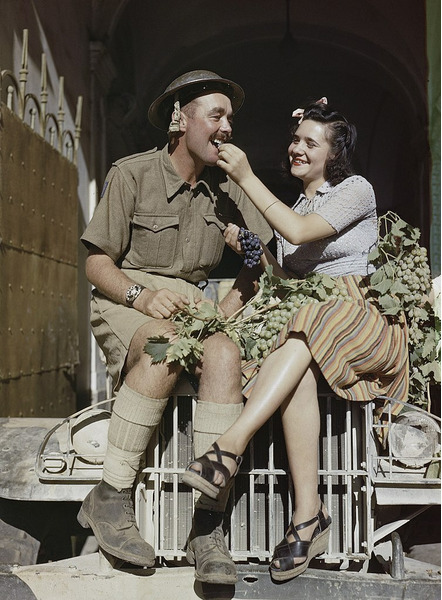 Солдат британской Восьмой армии наслаждается виноградом из рук сицилийки, август 1943-го