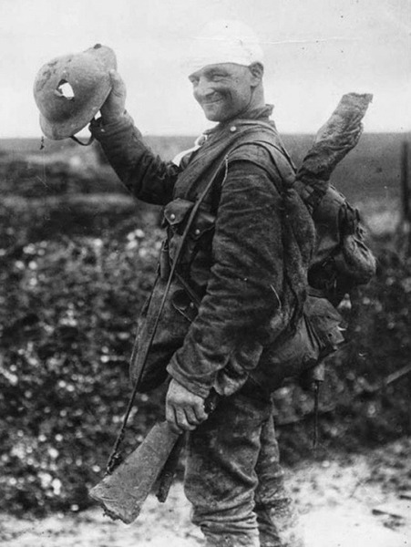 Везучий британский солдат показывает свой поврежденный шлем, 1918 год