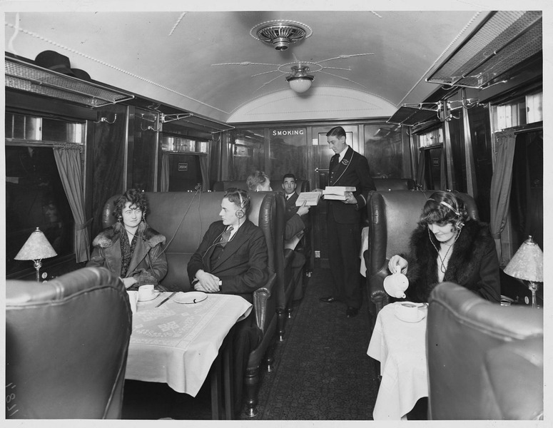 1930. Железнодорожный стюард раздает наушники