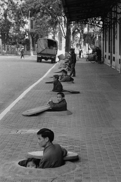 Жители Ханоя ждут сигнала отбоя воздушной тревоги во время воздушного налета. Вьетнам. 1967