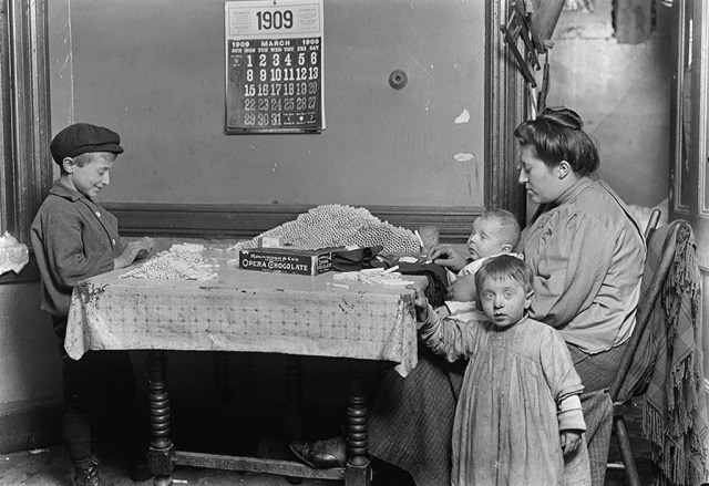 Вдова и мальчик сворачивают папиросные гильзы в квартире, Нью-Йорк, 1909 год