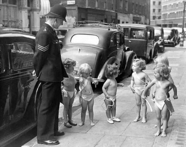 1947 год. Сержант полиции стоит рядом с шестью маленькими девочками, одетыми ангелами, возле Saville Theatre в Лондоне, где они принимают участие в утреннике, организованном в помощь Детской лиге жалости (Children’s League of Pity)