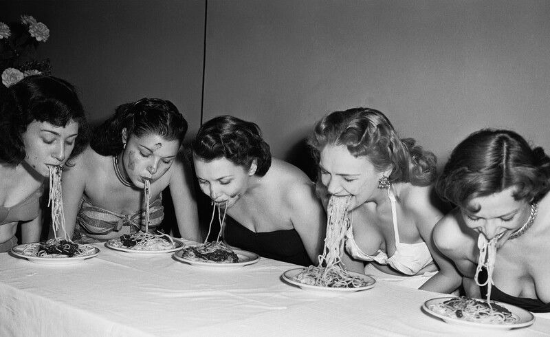 Девушки бродвейских шоу соревнуются в конкурсе по поеданию спагетти без рук, 1948 год.